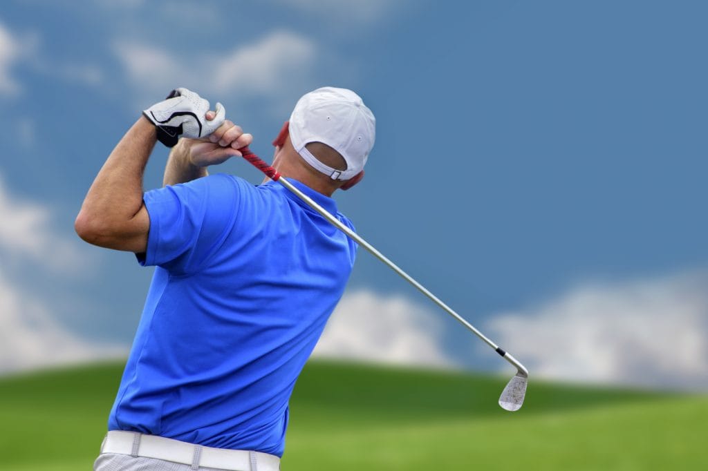 Pro golfer drives a golf ball.